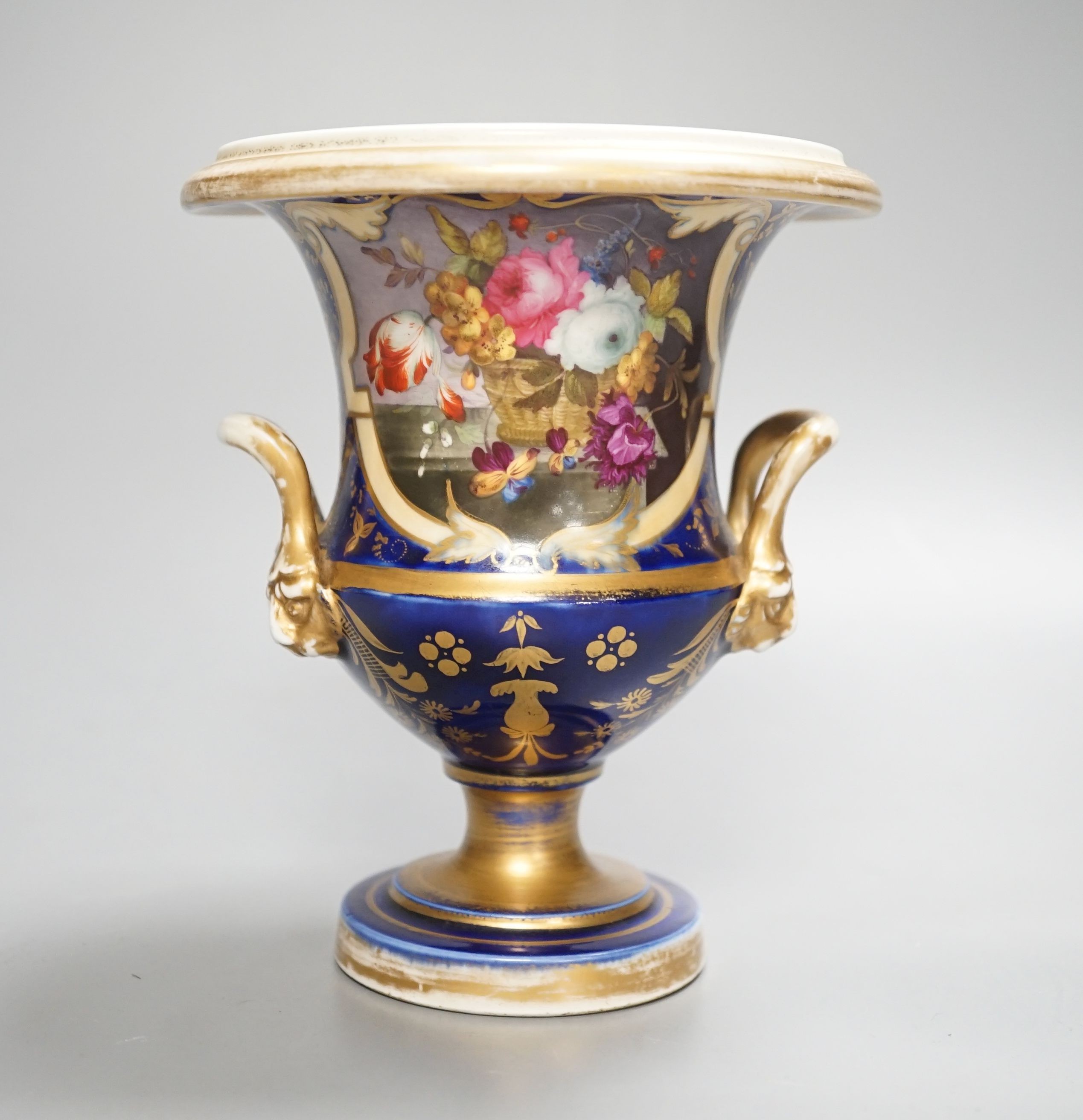 A Herculaneum two handled pedestal campana shaped vase, painted with basket of flowers, within a shaped cartouche on a cobalt blue and gilt ground, c.1815, height 14.5cm